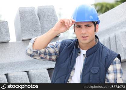 Construction worker in a hardhat next to concrete kerbing