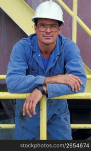 Construction worker in overalls and eyeglasses wearing hard-hat