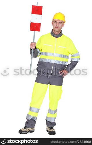 construction worker in safety outfit holding construction sign