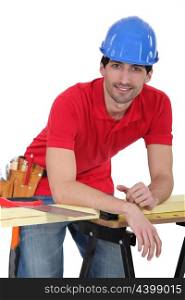 Construction worker leaning against his workbench