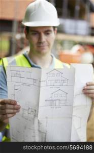 Construction Worker On Building Site Looking At House Plans