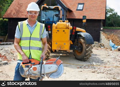 Construction Worker On Site Holding Circular Saw