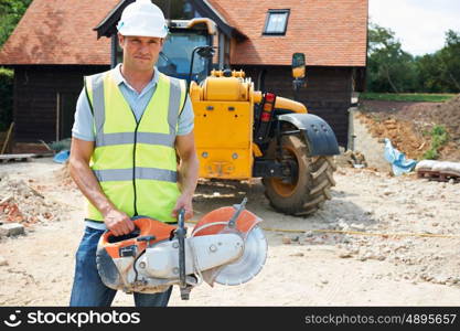 Construction Worker On Site Holding Circular Saw