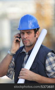 Construction worker on site with a phone