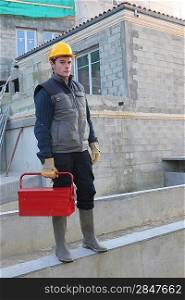 Construction worker on site with a toolbox