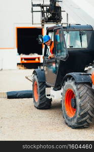 Construction worker operating on Skid Steer Loader