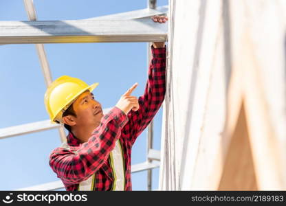 Construction worker or contractor checking house frame, worker roofer builder working on steel roof structure on building construction site