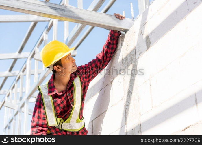 Construction worker or contractor checking house frame, worker roofer builder working on steel roof structure on building  construction site