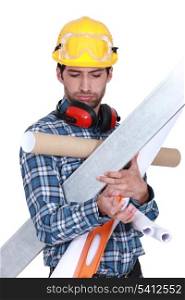 Construction worker overloaded with tools and building materials