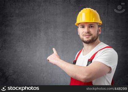 Construction worker pointing at the wall.