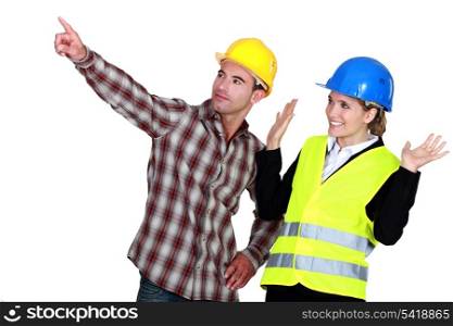 Construction worker pointing out a problem while his co-worker denies any involvement