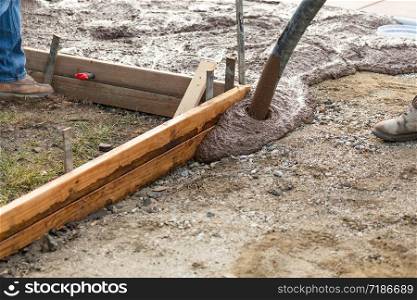 Construction Worker Pooring Wet Deck Cement Into Wooden Frame
