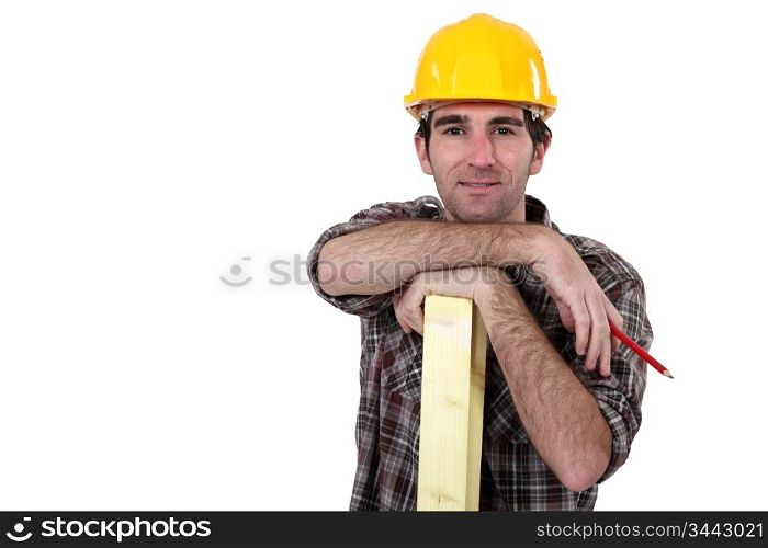Construction worker posing with a wooden plank