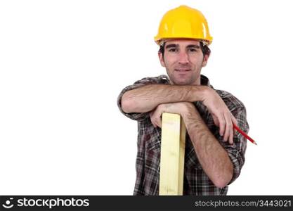 Construction worker posing with a wooden plank