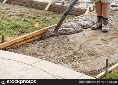 Construction Worker Pouring Wet Deck Cement Into Wooden Frame