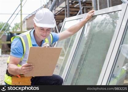 Construction Worker Preparing To Fit New Windows