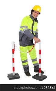 Construction worker putting up a barrier