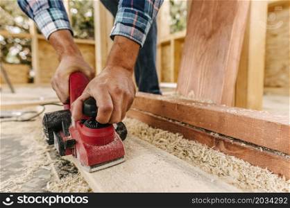 construction worker sanding down wood piece
