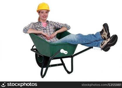 Construction worker sitting in a wheelbarrow
