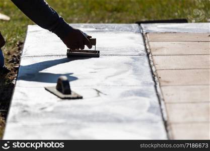 Construction Worker Smoothing Wet Cement With Hand Edger Tool