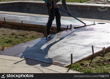 Construction Worker Smoothing Wet Cement With Trowel Tool