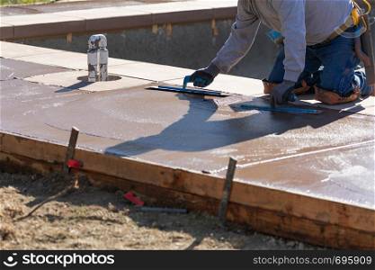 Construction Worker Smoothing Wet Cement With Trowel Tools
