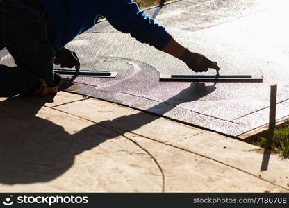 Construction Worker Smoothing Wet Cement With Trowel Tools