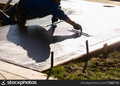 Construction Worker Smoothing Wet Cement With Trowel Tools