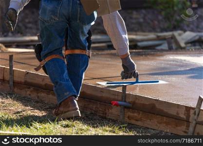 Construction Worker Smoothing Wet Cement With Trowel Tools