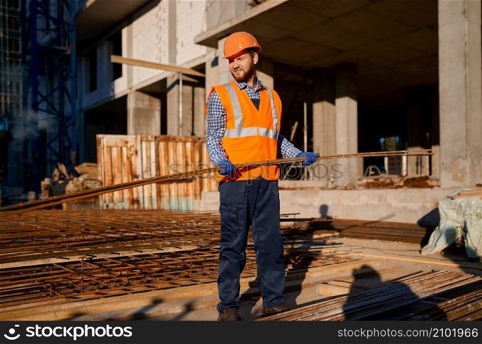 Construction worker taking metal grid reinforcing armature. Skeleton of future building at site. Construction worker taking metal grid reinforcing armature