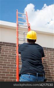 Construction worker using a ladder to climb to the top of a building.