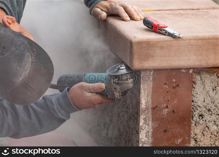 Construction Worker Using Grinder At Construction Site