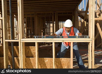 Construction worker using spirit level on construction site