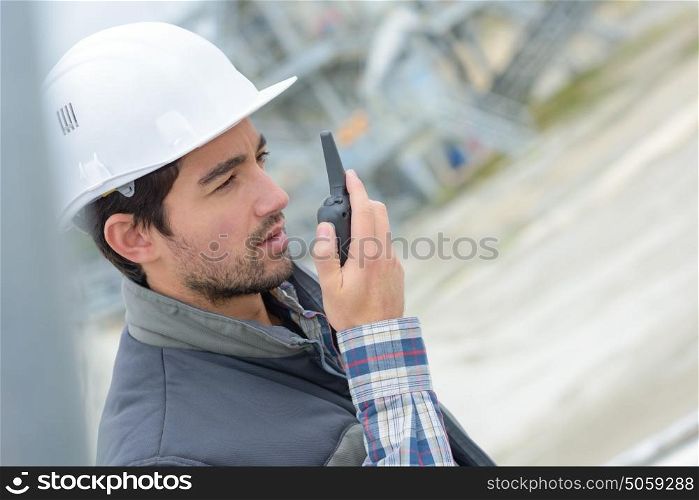 Construction worker using walkie talkie