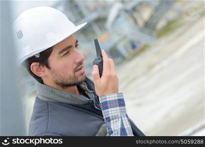 Construction worker using walkie talkie