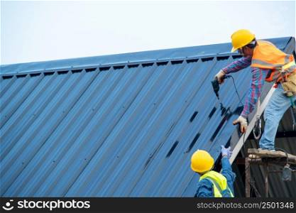 Construction worker wearing safety harness using secondary safety device connecting into 15 mm static rope using as fall restraint shingle on top of the new roof.