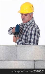 Construction worker with a masonry drill