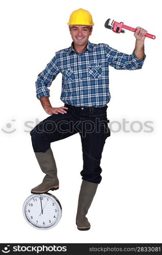 Construction worker with his foot on a clock