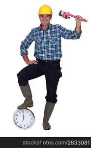 Construction worker with his foot on a clock