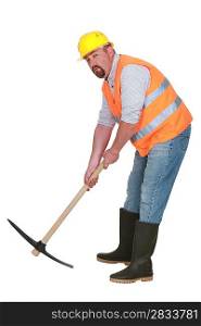 Construction worker with pickaxe on white background