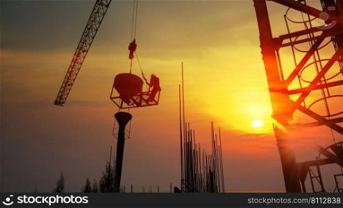 construction worker workloads in construction site . the worker put on cement reinforced in to the form with abstract sky sunset nature background