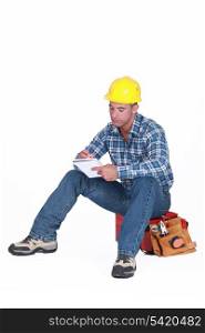 Construction worker writing in a notebook