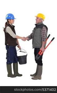 Construction workers handshaking, studio shot