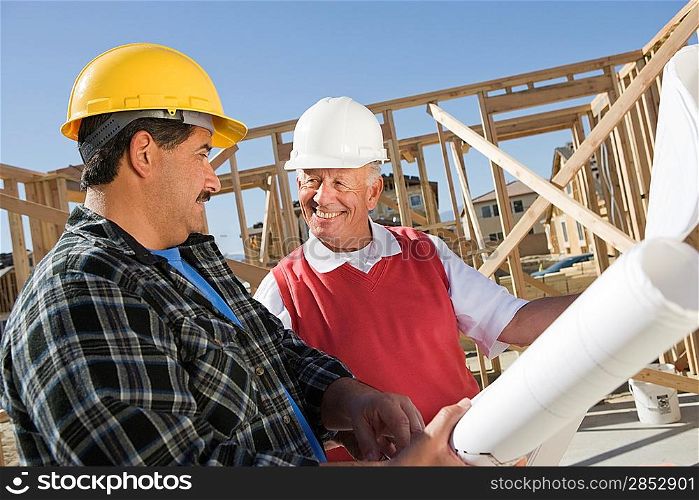 Construction workers observing plans on construction site