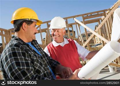 Construction workers observing plans on construction site