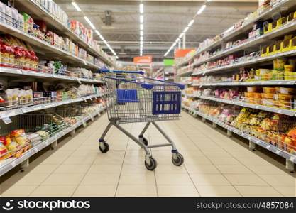 consumerism concept - empty shopping cart or trolley at supermarket. empty shopping cart or trolley at supermarket