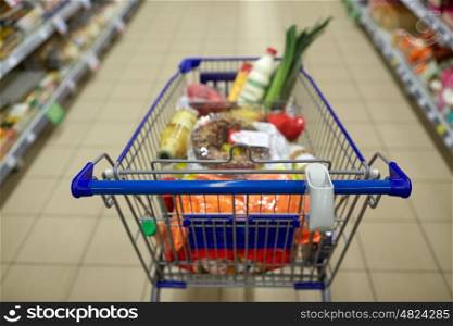 consumerism concept - food in shopping cart or trolley at supermarket. food in shopping cart or trolley at supermarket