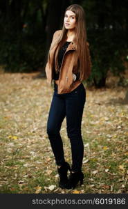 Consumerism, fashion and people concept - beautiful hippie young slim woman wearing boho chic clothes, suede jacket and trendy jeans. Autumn portrait.