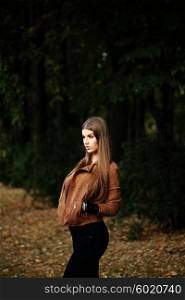 Consumerism, fashion and people concept - beautiful hippie young slim woman wearing boho chic clothes, suede jacket and trendy jeans. Autumn portrait.