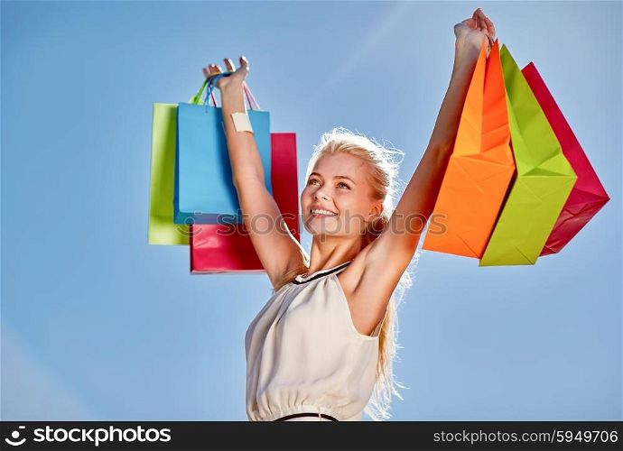consumerism, sale and people concept - smiling woman with shopping bag rising hands